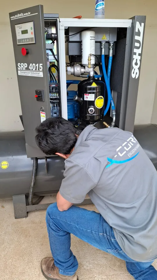 Técnico da ACORP Engenharia inspecionando compressor industrial Schulz