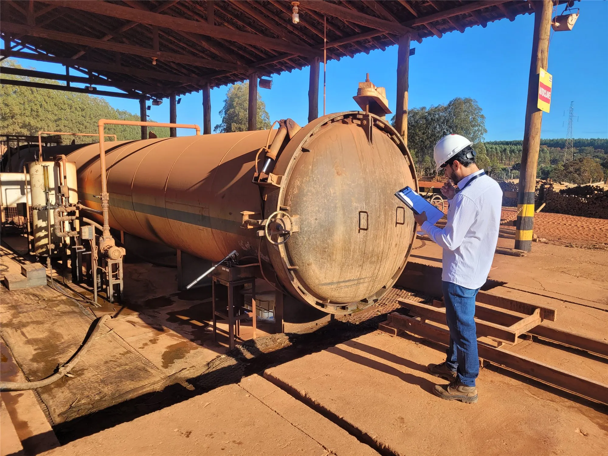 Engenheiro da ACORP inspecionando vaso de pressão de grande porte em campo